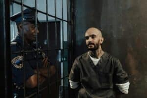 A tense encounter between a police officer and a prisoner inside a jail cell.