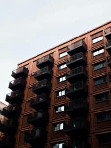 Contemporary apartment block with balconies in England; urban architectural style.
