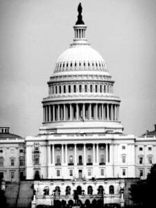 Black and white photo of the United States Capitol Building in Washington, D.C., showcasing its iconic dome.