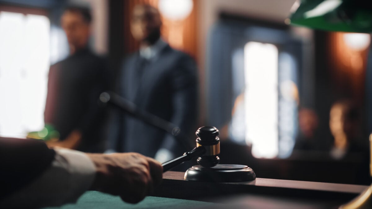 A courtroom in warm light with a gavel in the foreground.